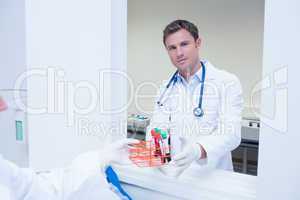 Smiling doctor standing behind blood sample