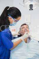 Dentist wearing surgical mask and safety glasses