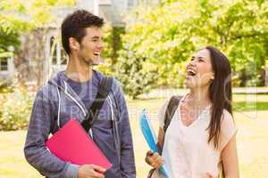 Smiling friends student standing with shoulder bag holding book