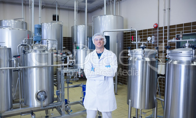 Scientist with arms crossed standing in front of container