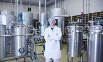 Scientist with arms crossed standing in front of container