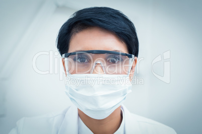 Dentist wearing surgical mask and safety glasses