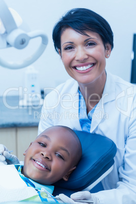 Portrait of female dentist examining boys teeth