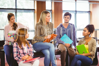 Happy students talking with their teacher