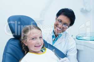 Female dentist examining girls teeth