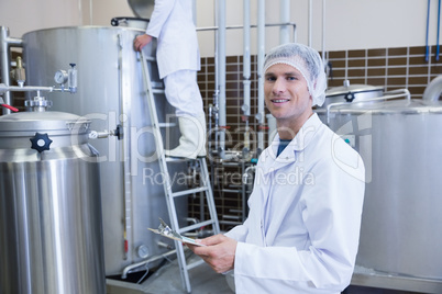 Scientist holding a clipboard and smiling at the camera