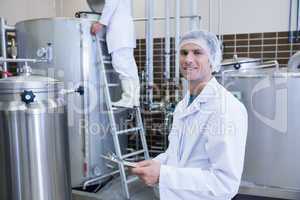 Scientist holding a clipboard and smiling at the camera