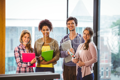 Four smiling classmates standing in front of the window