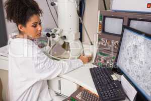 Biochemistry student using large microscope and computer