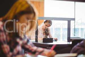 Focused student sitting next to the window taking notes