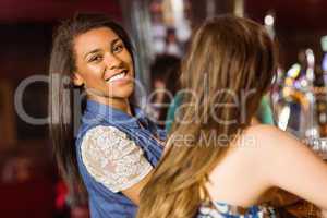 Portrait of a smiling brunette talking with her friend