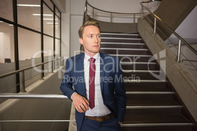 Handsome businessman standing on steps