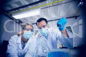 Science students using pipette to fill test tubes