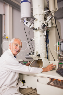 Biochemist using large microscope and computer