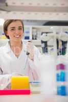 Pretty science student using pipette