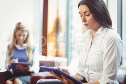 Thoughtful businesswomen using digital tablet