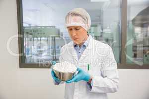 Pharmacist looking at bowl of pills