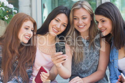 Happy students sitting in a row texting Happy students sitting in a row texting