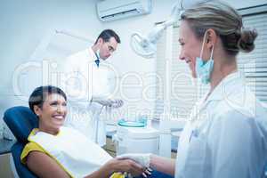 Female dentist shaking hands with woman