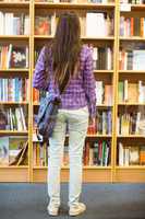 University student standing in the bookcase