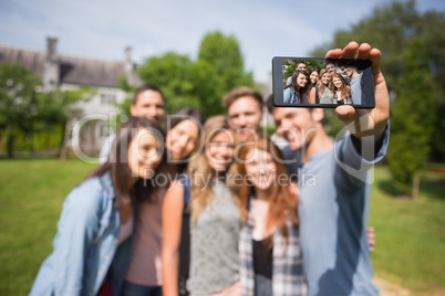 Happy students taking a selfie outside on campus