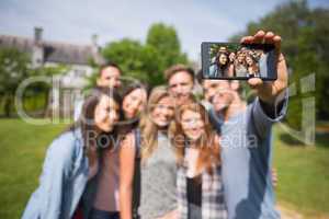 Happy students taking a selfie outside on campus