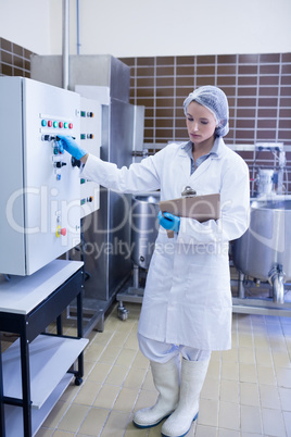 Focused biologist holding clipboard and pressing on button