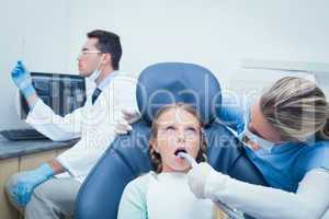 Female dentist examining girls teeth