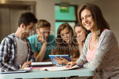 Smiling friends sitting studying and using tablet pc