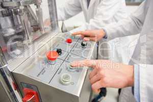 Pharmacist pressing button on machine