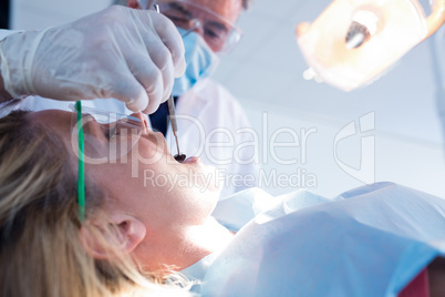 Dentist examining a patients teeth under bright light