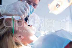 Dentist examining a patients teeth under bright light