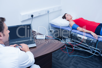 Doctor checking blood pressure of woman