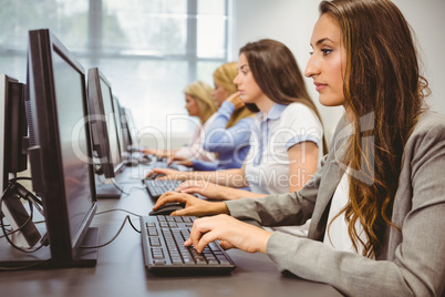 Four focused women working in computer room