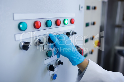 Hand with gloves turning buttons of the machine