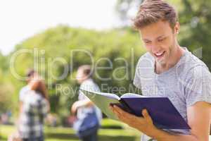 Handsome student studying outside on campus