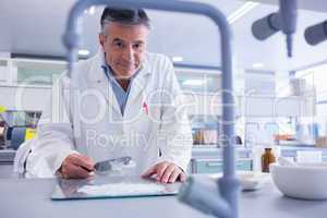 Smiling biochemist preparing some medicine