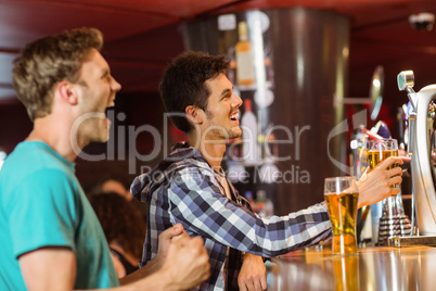 Happy friends sitting and drinking beer