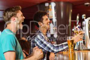 Happy friends sitting and drinking beer