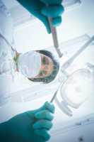 Female dentist in surgical mask holding dental tools