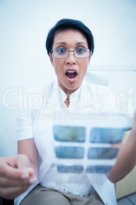 Shocked dentist looking at x-ray