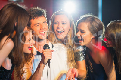 Happy friends singing karaoke together