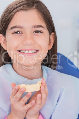 Smiling young patient holding teeth