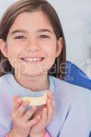 Smiling young patient holding teeth