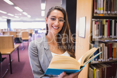 Pretty student reading book in library