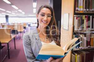 Pretty student reading book in library