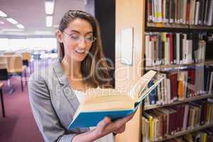 Pretty student reading book in library