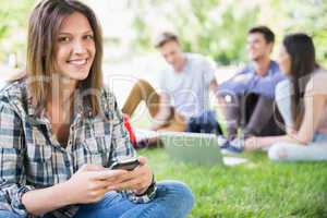 Happy students sitting outside on campus