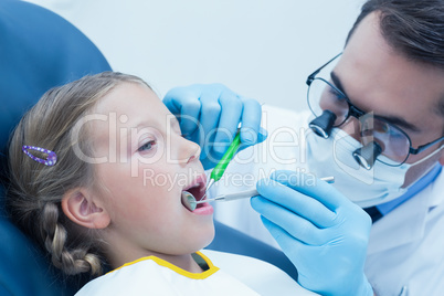 Male dentist examining girls teeth