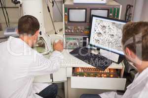 Biochemistry student using large microscope and computer